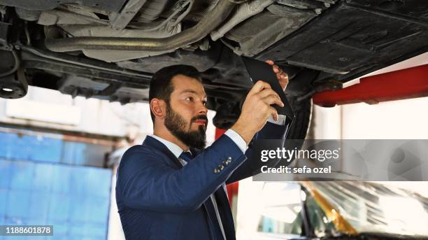 take a directly below photo at the auto repair shop for insurance - car underside stock pictures, royalty-free photos & images
