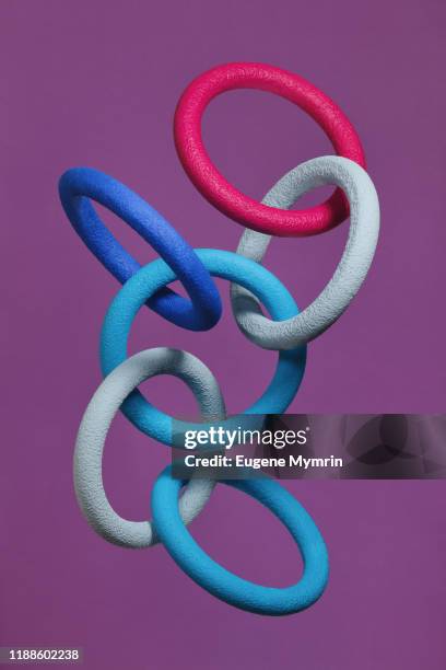 abstract multi-colored objects levitation in mid air on purple background - chain technology foto e immagini stock