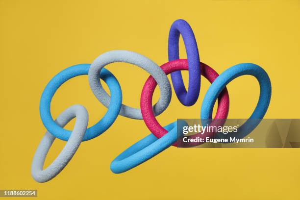 abstract multi-colored objects levitation in mid air on yellow background - link ストックフォトと画像