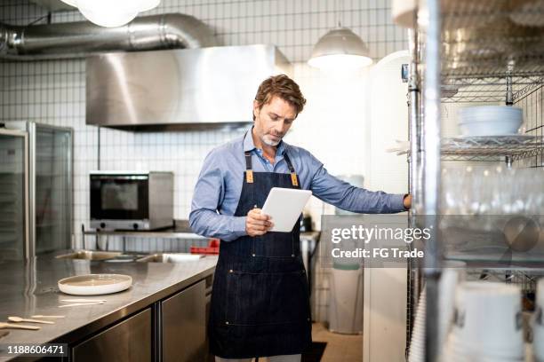 propietario del negocio revisando los suministros de cocina - food company manager fotografías e imágenes de stock