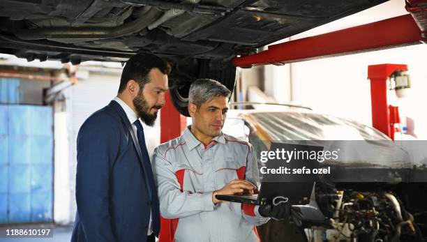 auto mechanic showing data on the computer - auto shop manager stock pictures, royalty-free photos & images