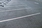 Empty outdoor parking lot space marked with white lines. Can accommodate car a lot. soft focus.