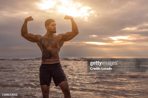 handsome brunette ethnic man during workout - muscle men at beach stock pictures, royalty-free photos & images