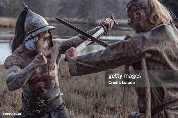 zwei starke wikinger männer kämpfen in der hand zu hand kampf - militante gruppe stock-fotos und bilder
