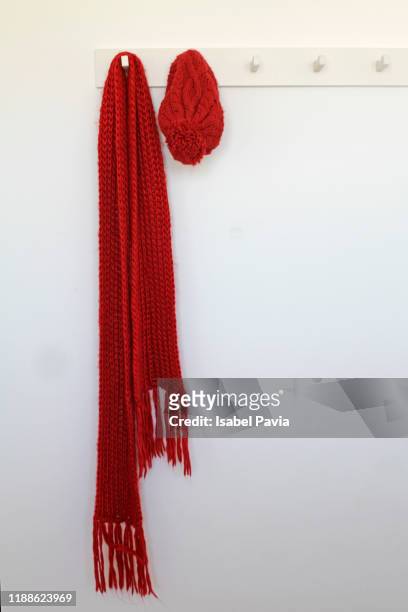 red scarf and hat hanging on rack - winter scarf stock pictures, royalty-free photos & images