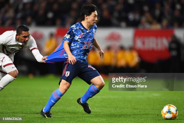 Shoya Nakajima of Japan and Bernaldo Manzano of Venezuela compete for the ball during the international friendly match between Japan and Venezuela at...