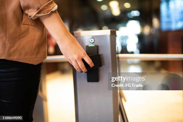 businesswoman passing by the turnstile - entering turnstile stock pictures, royalty-free photos & images