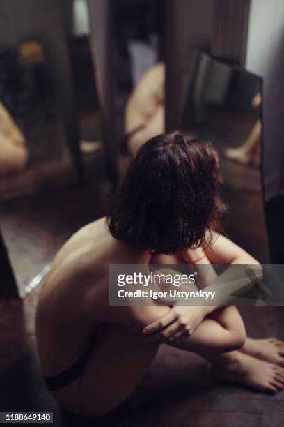 young woman sitting between the mirrors - anoressia foto e immagini stock