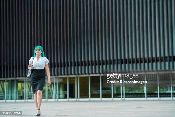 blue-haired latin woman in elegant dress walks outside the university - unleash creativity stock pictures, royalty-free photos & images