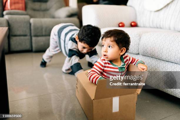 kids playing with boxes on christmas morning - baby imagination stock pictures, royalty-free photos & images