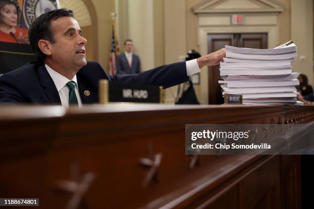 Rep. John Ratcliffe gestures to a stack of transcripts of depositon as Lt. Col. Alexander Vindman , National Security Council Director for European...