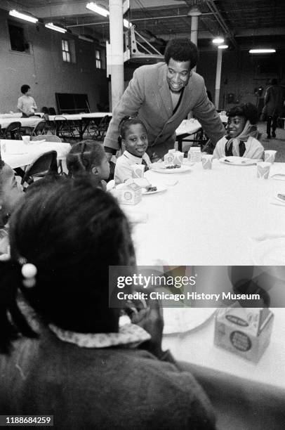 American social activist and Illinois Black Panther Party chapter chairman Fred Hampton speaks with school children during a free breakfast program,...