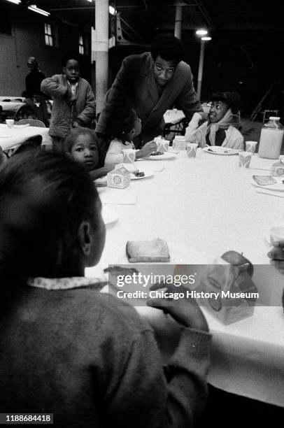 American social activist and Illinois Black Panther Party chapter chairman Fred Hampton speaks with school children during a free breakfast program,...