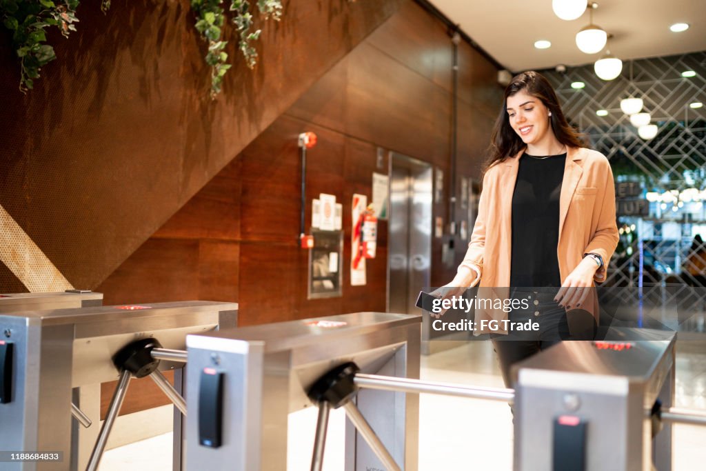 Businesswoman passing by the turnstile
