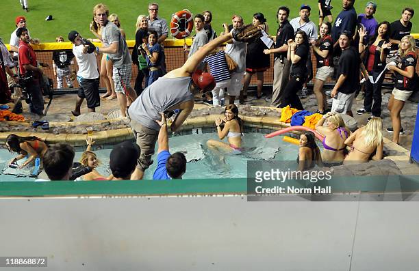 Fan catches a home run ball in the pool during the 2011 State Farm Home Run Derby at Chase Field on July 11, 2011 in Phoenix, Arizona.