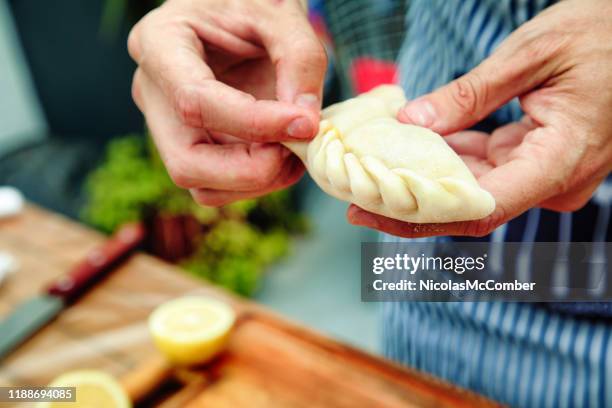 close-up on male hands folding homemade empanadas tucumanas - empanada imagens e fotografias de stock