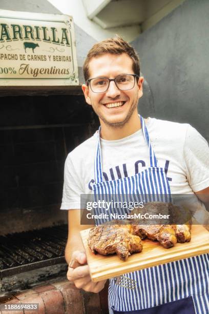 milleniaino cocinero argentino que presenta costilla asada ojo de costilla y filetes de tiras - argentina steak fotografías e imágenes de stock