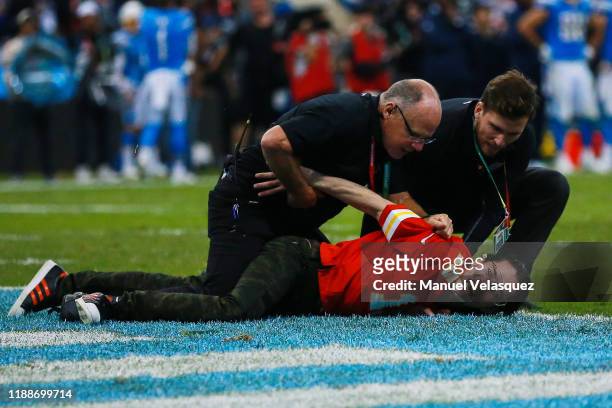 Security guards apprehend an unidentified man who ran on to the field during the game between the Kansas City Chiefs and the Los Angeles Chargers at...