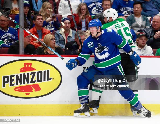 Miller of the Vancouver Canucks checks Roman Polak of the Dallas Stars during their NHL game at Rogers Arena November 14, 2019 in Vancouver, British...