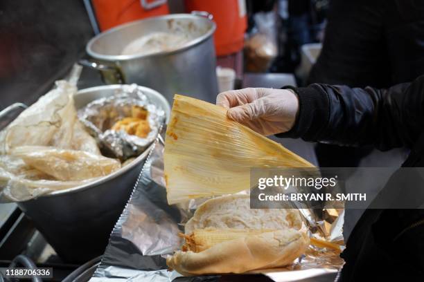 Street vendor sells tamales at Junction Blvd. In the Queens Borough of New York City on November 27, 2019. - Street vendors are regularly the target...