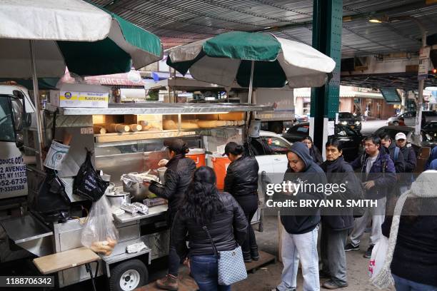 Street vendor sells tamales at Junction Blvd. In the Queens Borough of New York City on November 27, 2019. - Street vendors are regularly the target...