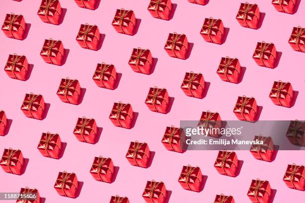 red gift box on pink background - still life foto e immagini stock