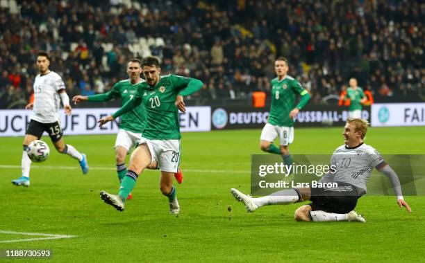 Julian Brandt of Germany scores his team's sixth goal as Craig Cathcart of Northern Ireland reacts during the UEFA Euro 2020 Qualifier between...