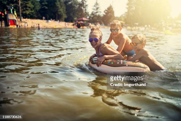 kids enjoying playing in lake - lake boat stock pictures, royalty-free photos & images