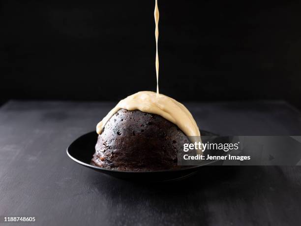 custard pouring over christmas pudding. - カスタード ストックフォトと画像