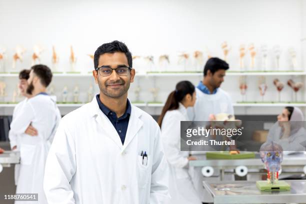 verticale de jeune étudiant indien de médecine mâle - scientifique blouse blanche photos et images de collection