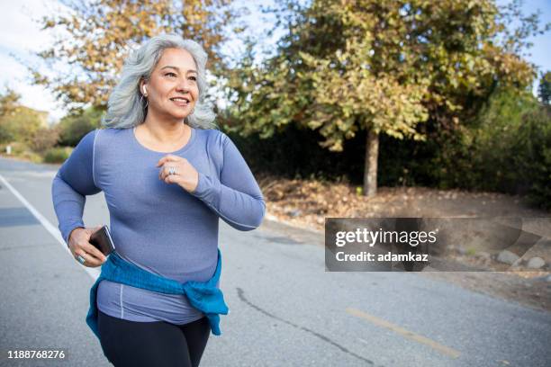 mexicaanse vrouw joggen - actieve ouderen stockfoto's en -beelden