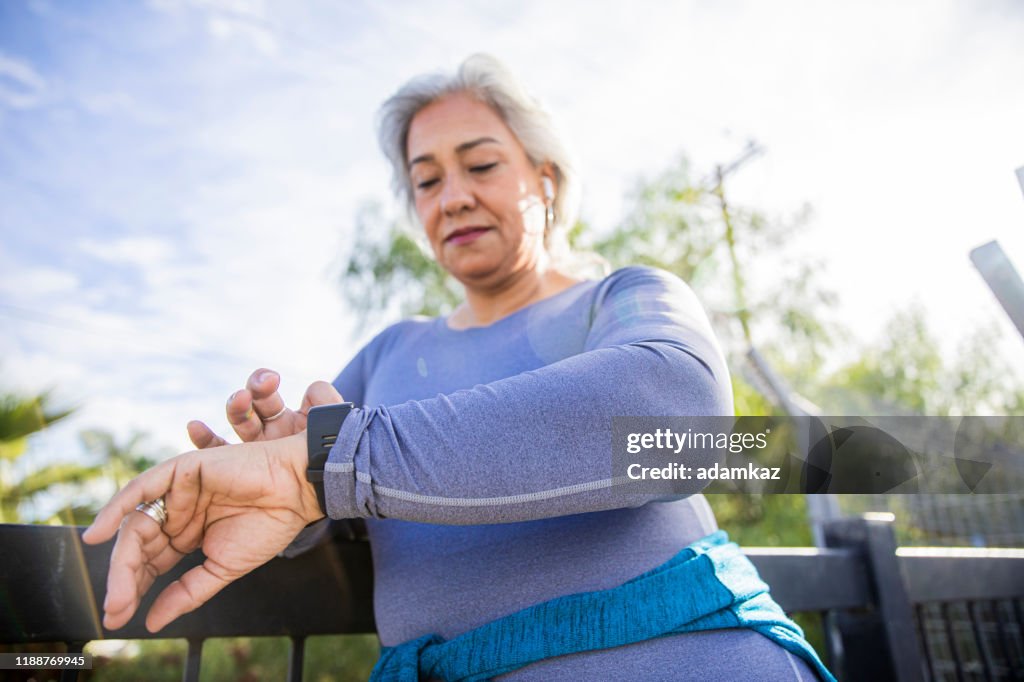 Volwassen Mexicaanse vrouw met behulp van fitness tracker