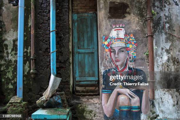 Mural painting shows a woman from the Akha ethnic minority in a street renovated under the Yangon Walls Project. The Yangon Walls project was...