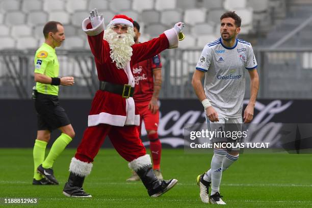 Man dressed as Santa Claus gestures on the pitch before the start of the French L1 football match between Bordeaux and Strasbourg on December 15,...