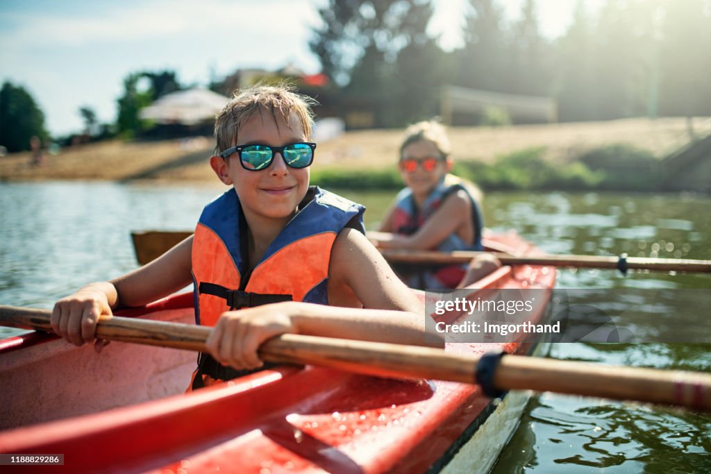 Two boys enjoying kayaking on lake