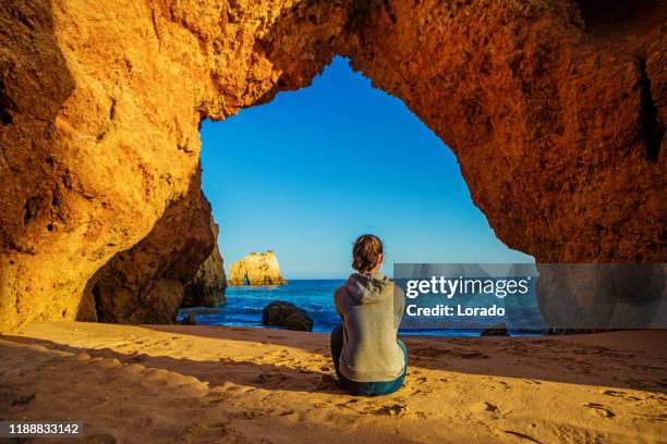 young brunette female enjoying her freedom on the seafront in alvor portugal in late summer sun - algarve stock pictures, royalty-free photos & images