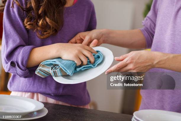 moeder en dochter reinigen platen samen - vod stockfoto's en -beelden