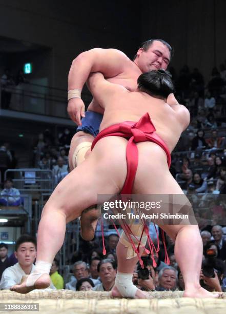 Onosho pushes Kotoshogiku out of the ring to win on day ten of the Grand Sumo Kyushu Tournament at the Fukuoka Convention Centre on November 19, 2019...
