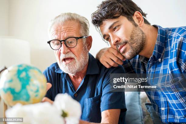 happy family of father and son prepare to travel trip, learn for route together at living room. - travel agency stock pictures, royalty-free photos & images