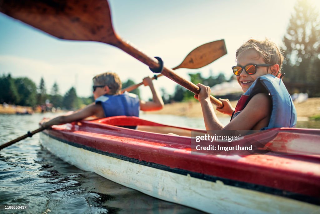 Two boys enjoying kayaking on lake