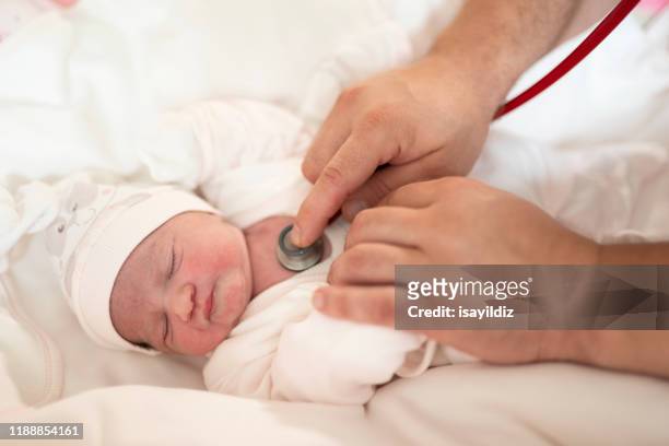 newborn baby and doctor stock - examining newborn stock pictures, royalty-free photos & images