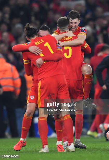 Wales player Ben Davies jumps into the arms of Chris Mepham to celebrate after the UEFA Euro 2020 qualifier between Wales and Hungary at Cardiff City...