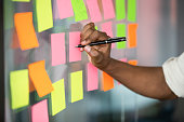 Close up african american manager writing notes on kanban board.