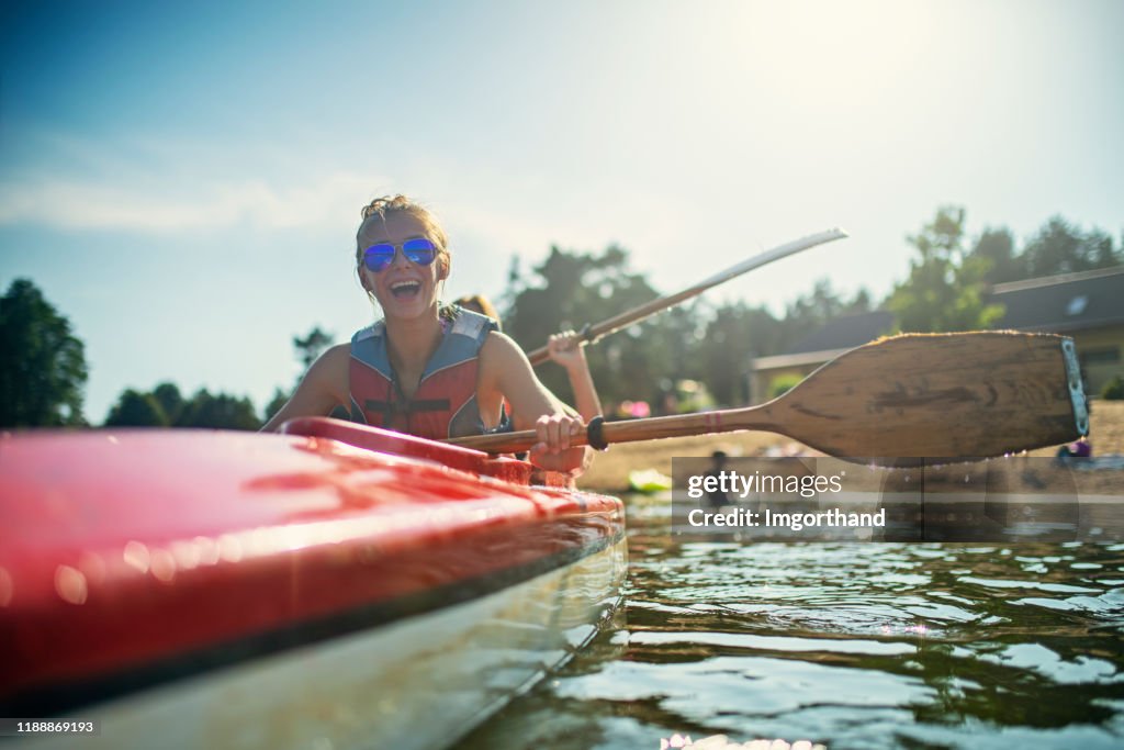 Teenage girl and mother enjoying kayaking on lake