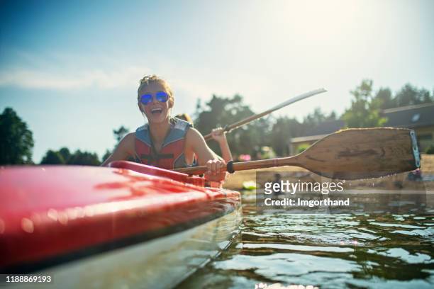 teenage girl and mother enjoying kayaking on lake - kayak imagens e fotografias de stock