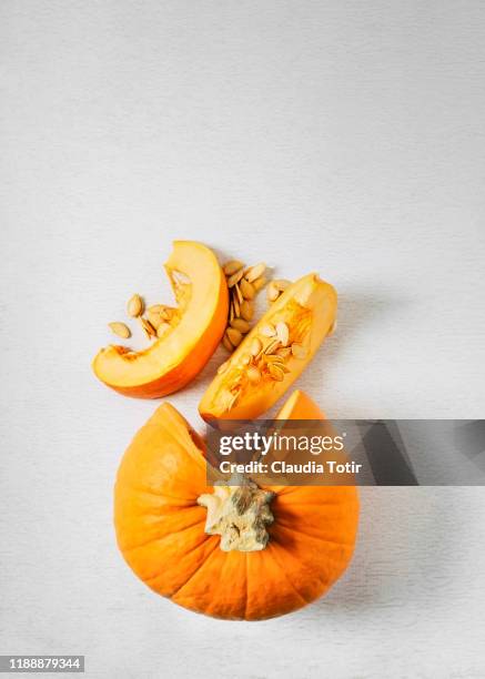 sliced pumpkin on white background - squash seeds stock-fotos und bilder