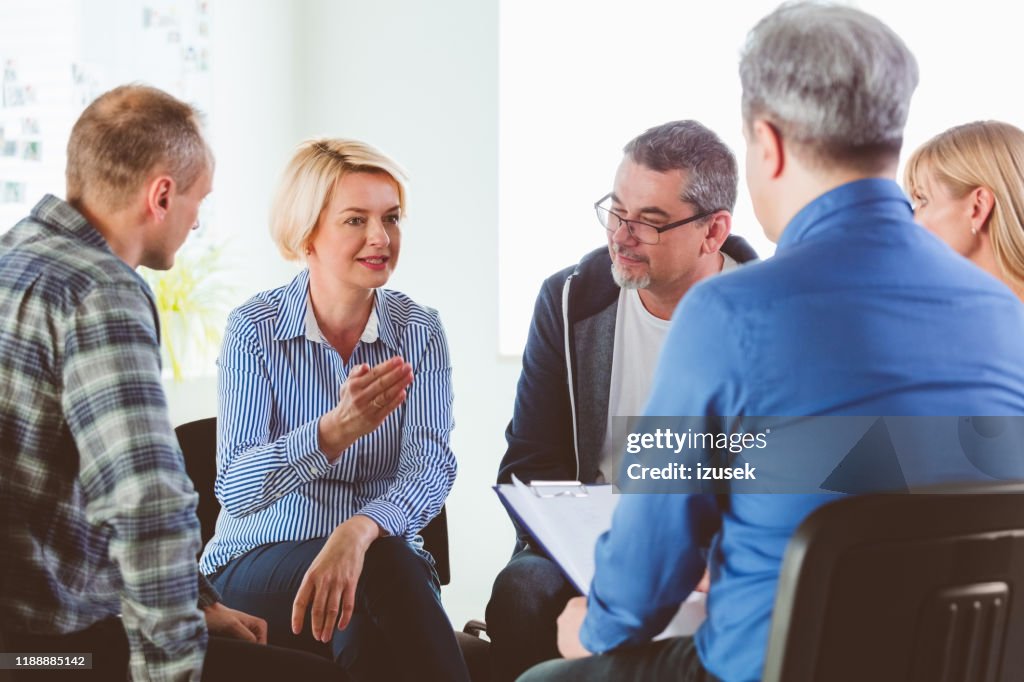 Blond mature woman sharing issues during meeting