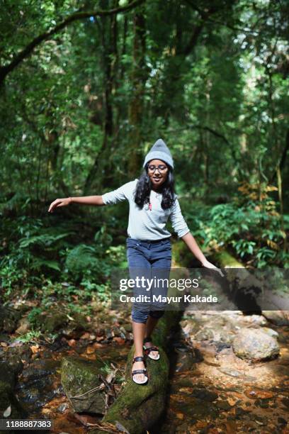 preadolescent girl walking on the fallen tree trunk - 11 year old indian girl stock pictures, royalty-free photos & images