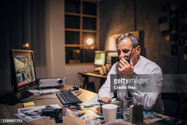 ein alter detektiv verwendet einen walkie-talkie - secret service agent stock-fotos und bilder