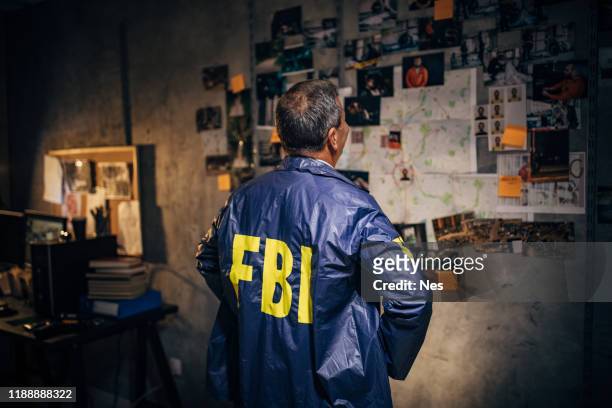 the old detective works alone late at night in his office - fbi stock pictures, royalty-free photos & images